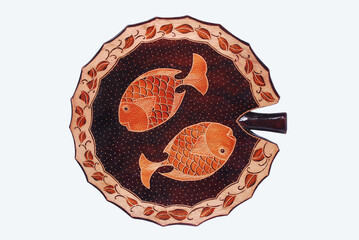 Decorative plate made of wood with a picture of a fish. Souvenirs of such handicraft products are usually wall decorations or displayed in the room 