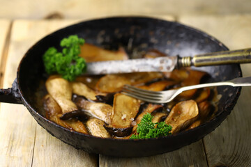 Fried eringi mushrooms in a pan. Mushroom dish.