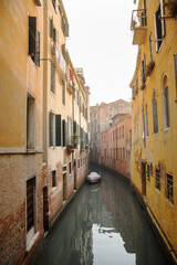 Fototapeta na wymiar Bote solitario aparcado en un canal de venecia debajo de las ventanas de las viviendas