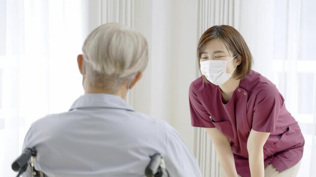 患者に話をするマスクを着用した看護師