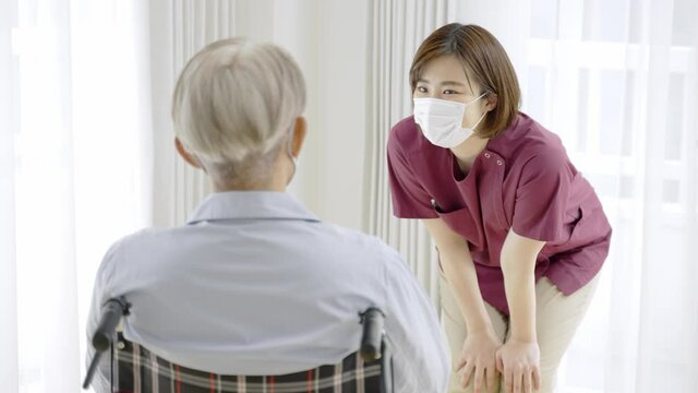 患者に話をするマスクを着用した看護師