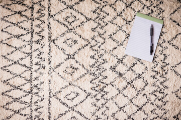notepad and pen on bedroom rug