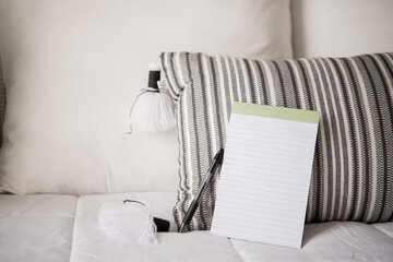 notepad and pen leaning on pillow