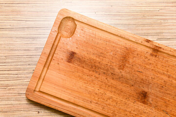 Old chopping board on wooden background top view
