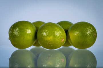 Limes on a blue background with low reflection