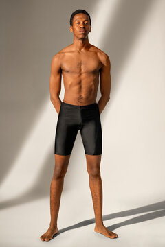 Handsome man in black swim shorts summer fashion full body