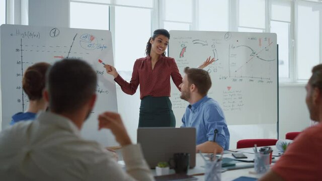 Happy woman making presentation office. Business team celebrating success.