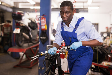 Fototapeta na wymiar Service engineer repairs a motorcycle steering wheel in a motorcycle service. High quality photo