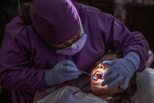 Dentista mexicana, chequeo m&eacute;dico de la cavidad bucal de la paciente con instrumentos dentales