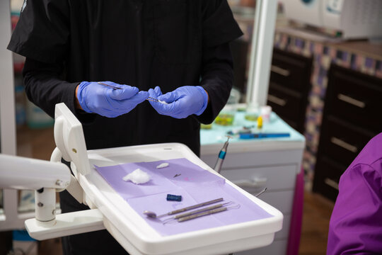 Asistente de dentista preparando instrumentos dentales
