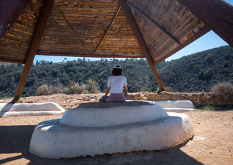 Woman meditating in wooden tipi © Yo Creo Content