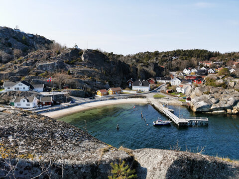 Beautiful shot of a rocky shore with houses ne the sea in Kjerringvik, Norway