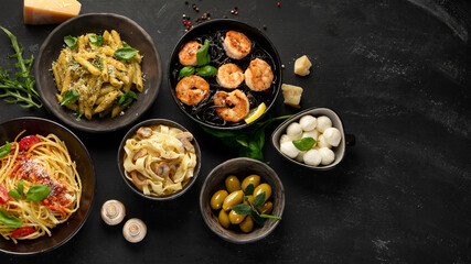 Assortment of Italian pasta with traditional sauces for dinner on dark background.