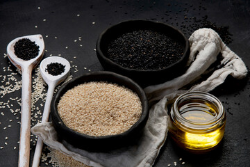Black and white sesame seed on black background. Organic food concept