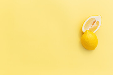 Two halved cuts of lemon with shadow on yellow background