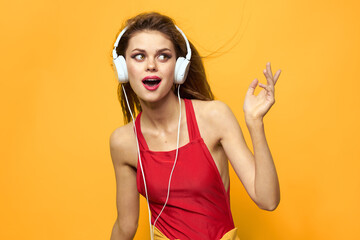 woman in headphones listening to music red t shirt emotions fashion yellow background lifestyle