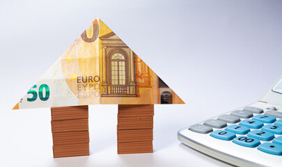 House made of brick stacks with a 50 euro note as a roof. Home loan real estate for mortgage concept