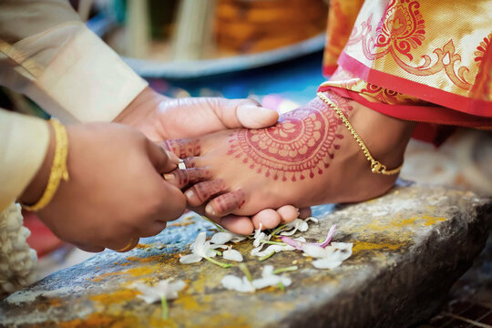 bridegroom insert ring on the leg finger of women in the Hindu wedding