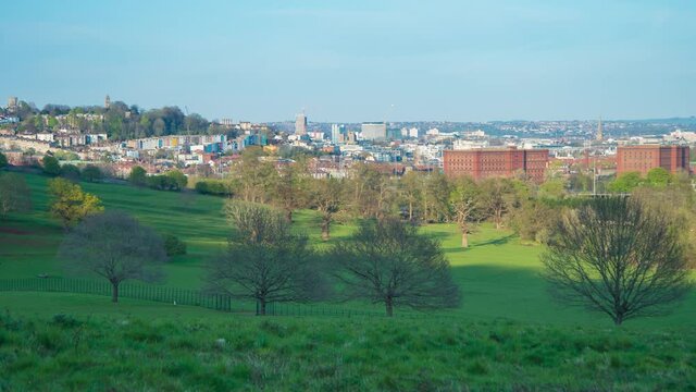 Time lapse of sunlight over green meadows and city of Bristol, England