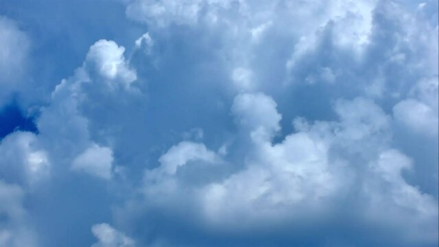 The motion of White Fluffy Clouds In Blue Sky. Time-Lapse of Beautiful blue sky on a summer day with white cumulus.