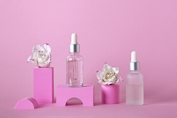 Beauty skincare product mock up. Serum bottles and flowers on different geometric podiums for branding and packaging presentation