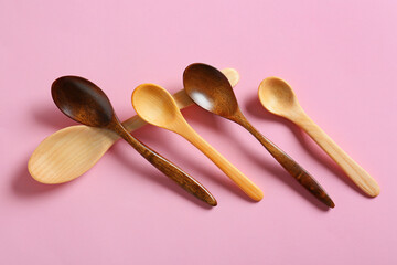 Different wooden spoons on color background