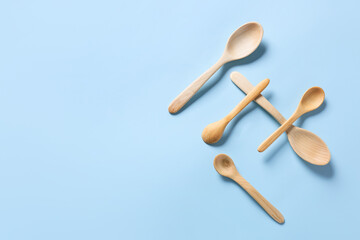 Wooden spoons on color background