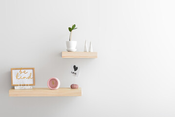Shelves with alarm clock and decor on white wall