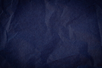 top view of empty crumpled wrinkled tissue paper dark blue color with vignette.
