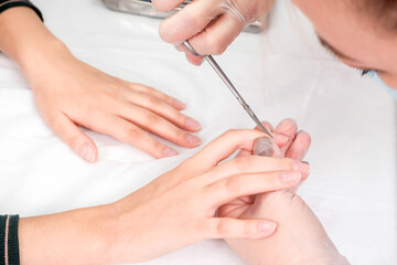 Obraz na płótnie Canvas Close-up of female hands during a manicure procedure in the salon.