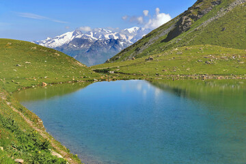 Fototapeta na wymiar beautiful lake in alpine mountain lake with snowy peak mountain background