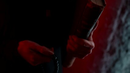 exorcist woman is reading bible and holding rosary beads, closeup of hands in dark room