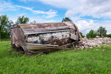 landscape with overturned old water tower, wooden barrel on the ground, fragments of white brick ruins, Latvia, Vaidava