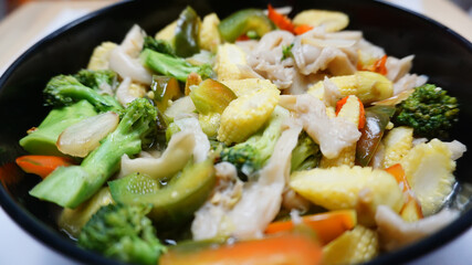 Vegetable capcay young corn with mushrooms and also peppers seen up close squatted black color