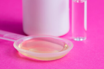 Ampoule with medicine, medicinal mixture and white jar of pills on pink background