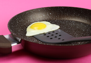 Spatula lifts scrambled eggs in a frying pan close-up
