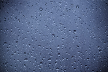Water drops on the colored window glass. Abstract: water and glass. Concept: humidity.