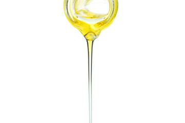 Olive oil pouring from the bottle, isolated on white background