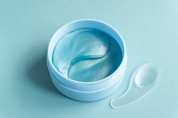 open jar with collagen anti-ageing patches for the eyes and face. Close up, top view.