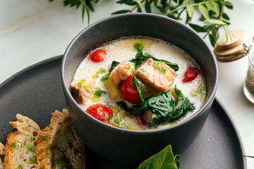 Creamy soup with salmon spinach and crispy french baguette