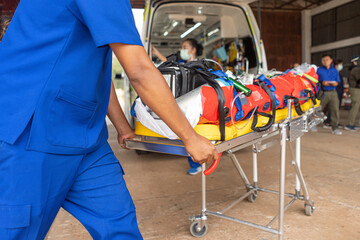 A nurse worker is pushing a stretcher to be taken to an ambulance for transport. © thanarak