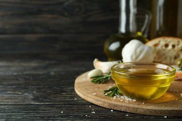 Concept of tasty eating with bowl of olive oil on wooden table, space for text
