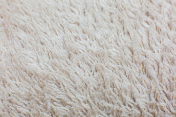 Beige cotton towel or carpet fluffy texture background. Close up, macro photo. Soft focus image. Rug.