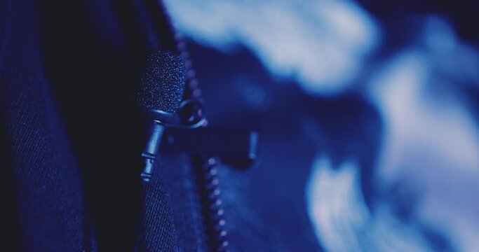 Close up of attaching a wired interview lavalier microphone to clothing