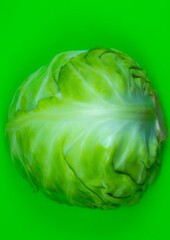 Fototapeta premium Green cabbage on the green background. Close up. Macro photo. Minimalism, original beautiful food photo.