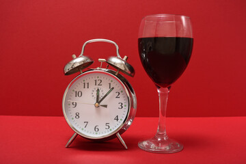 glass of red wine next to an alarm clock 