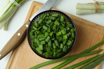 Fresh green onion on cutting board on white background
