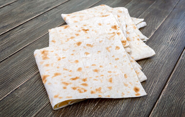 Thin pita bread on wooden background. Lavash - tasty hearty healthy Armenian and Turkish unleavened flat bread.