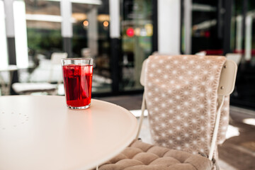 Cool red beverage on the white table in cafe terrace