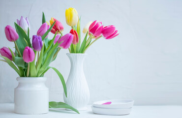 Home decoration with spring tulips bouquets in white vases
